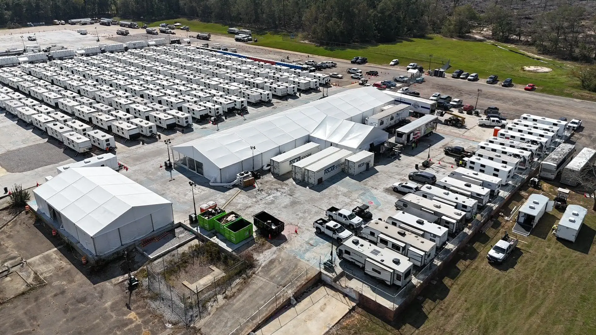 Aerial view of a workforce camp: rows of sleeper trailers, clear-span dining structures and refrigerated storage