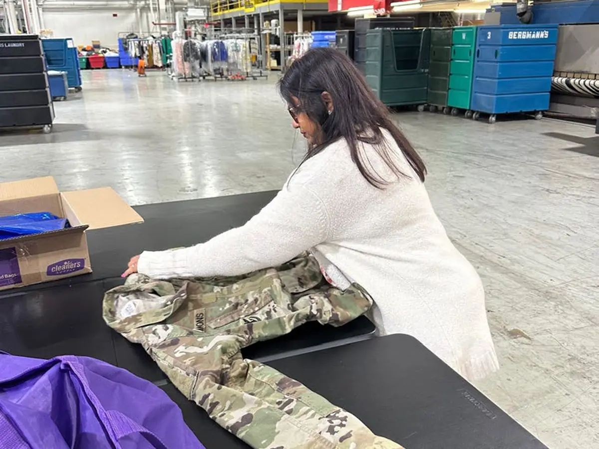Uniform being folded at a commercial laundry facility