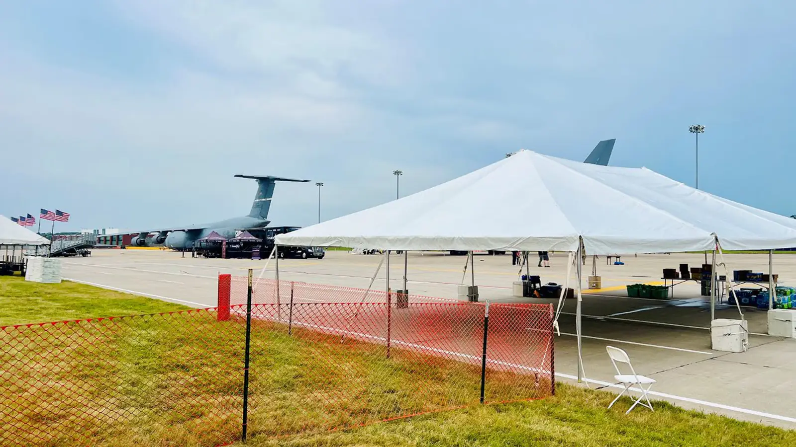 Frame tent on a flight line beside military transport aircraft